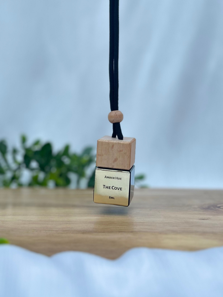 Wooden pendant with 'The Cove' branding on a blurred background